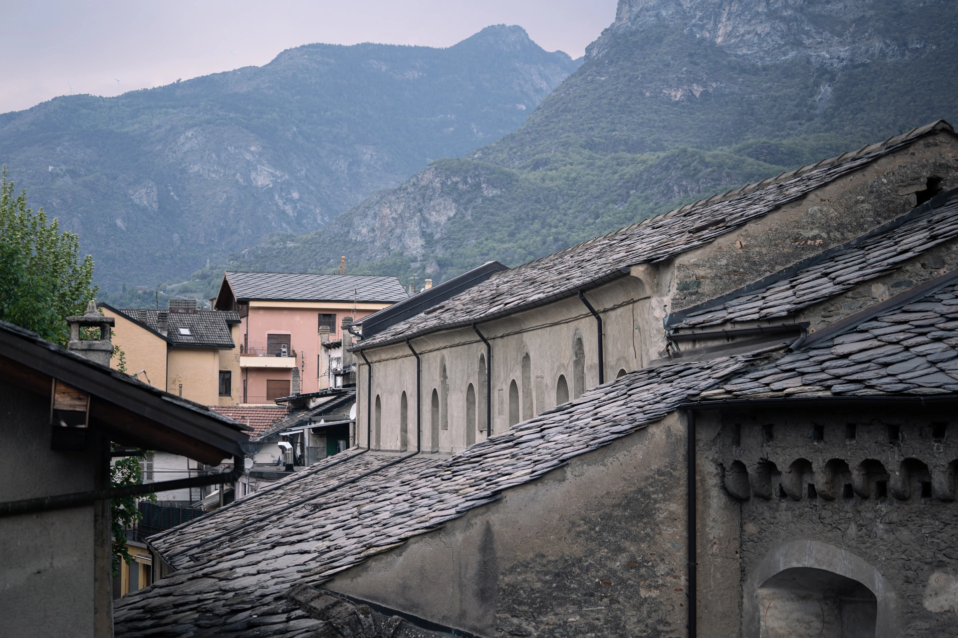 Tiled village roofs with mountains rising in the background