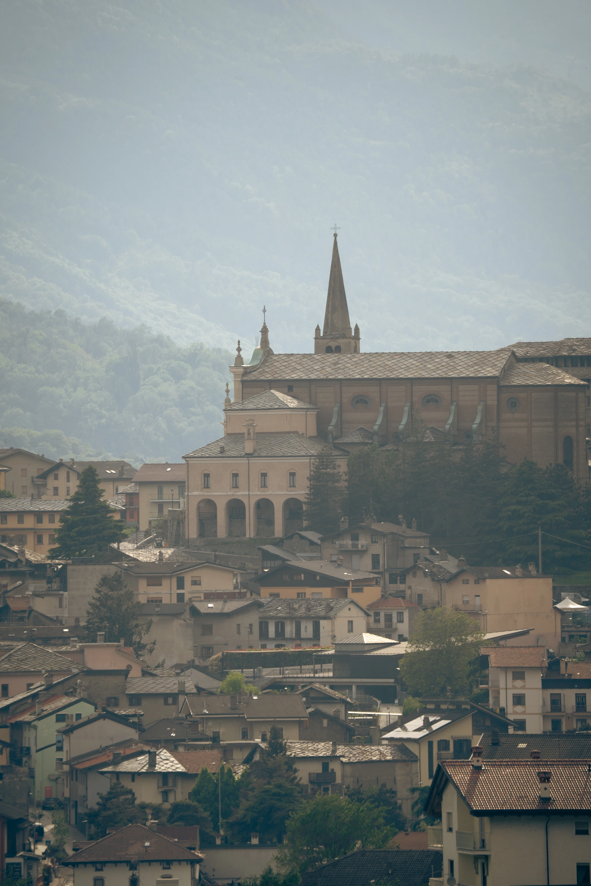 A hillside town and church spire in soft mountain light